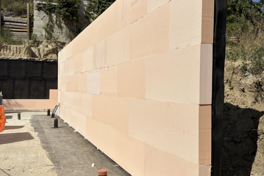 Stone-clad retaining wall at the side facade of the detached house